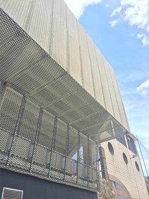 Un edificio con un balcón y un cielo azul al fondo.