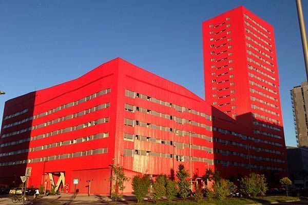 Un gran edificio rojo con un cielo azul al fondo.
