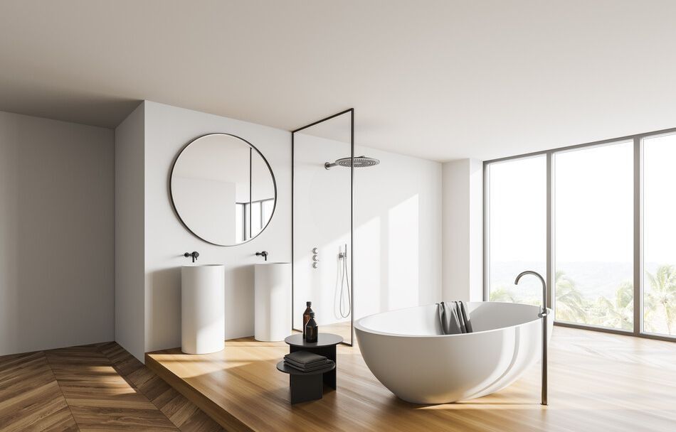 Un baño con bañera, lavabo y una gran ventana.