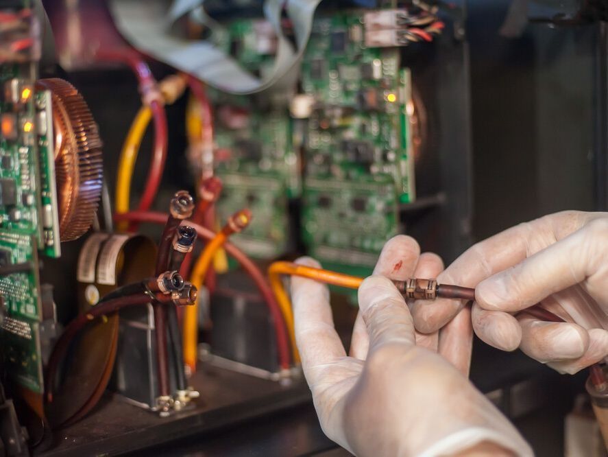 Una persona que lleva guantes está trabajando en la placa base de una computadora.