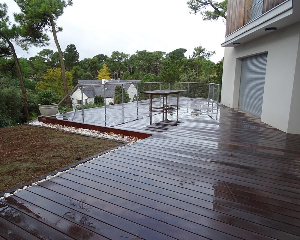 terrassement en bois foncé devant une maison