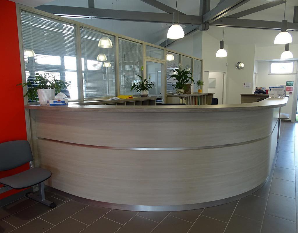 comptoir moderne en bois clair destiné à l'accueil des client