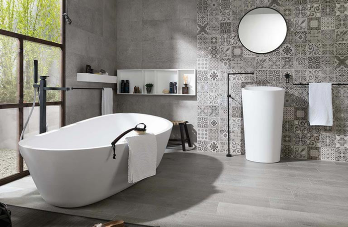 baignoire en premier plan d'une salle de bain au design moderne gris et blanc