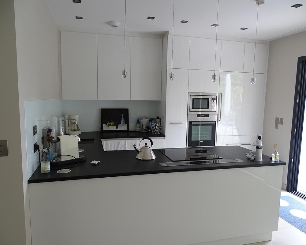 cuisine aménagée en bois laqué blanc et plan de travail foncé