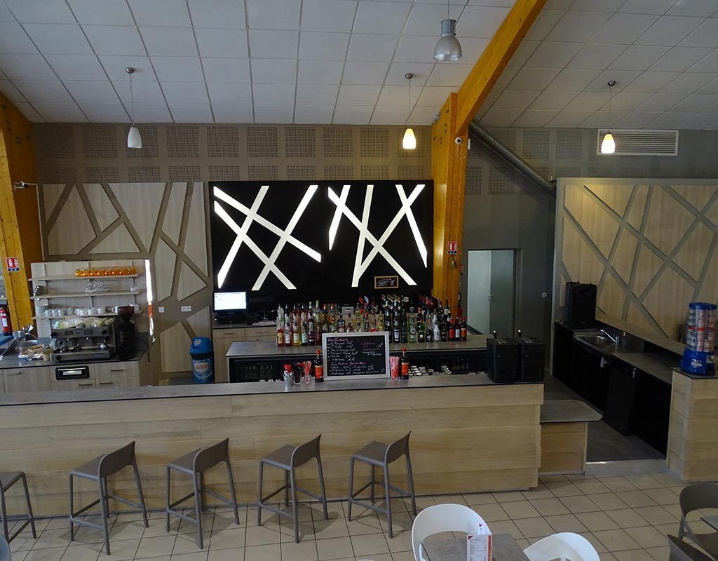 comptoir de bar en bois naturel et décoration design en arrière plan