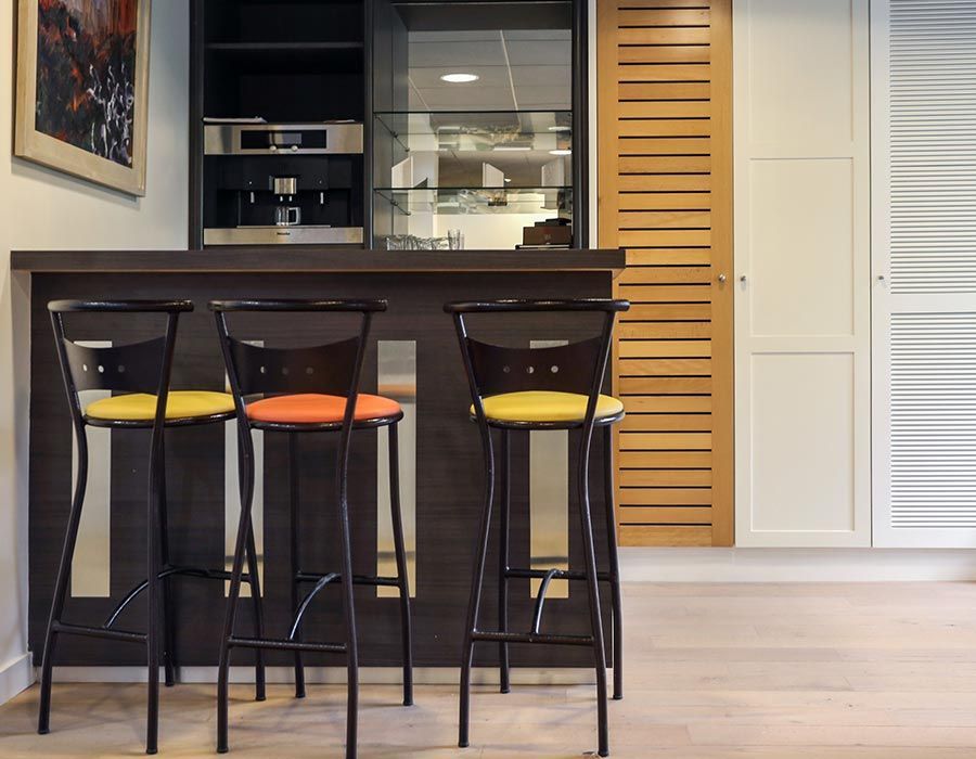 table de bar noire et chaises avec des assises colorées