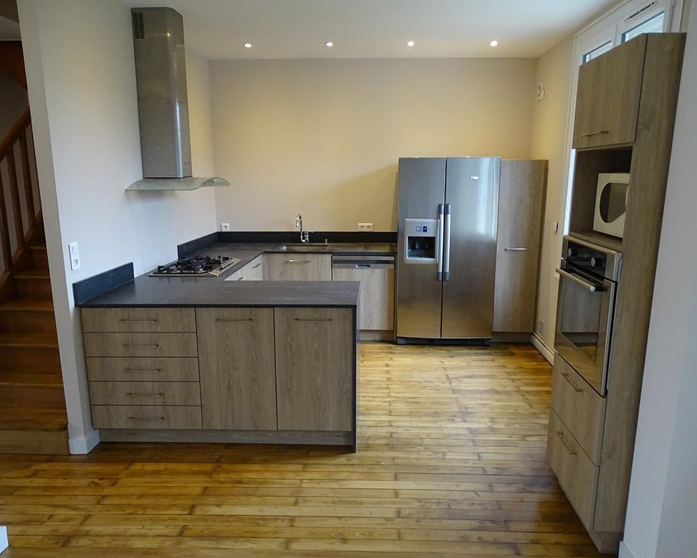 cuisine aménagée en bois grisé avec des plans de travail gris