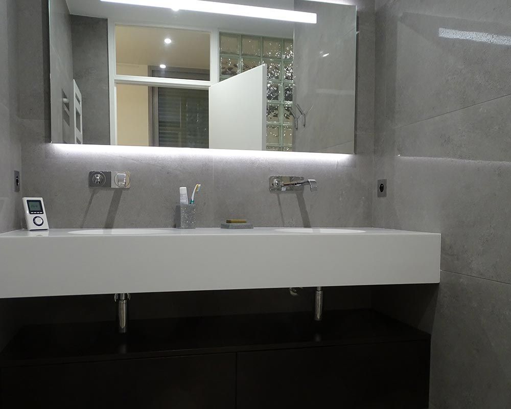 lavabo de couleur blanche et miroir éclairé