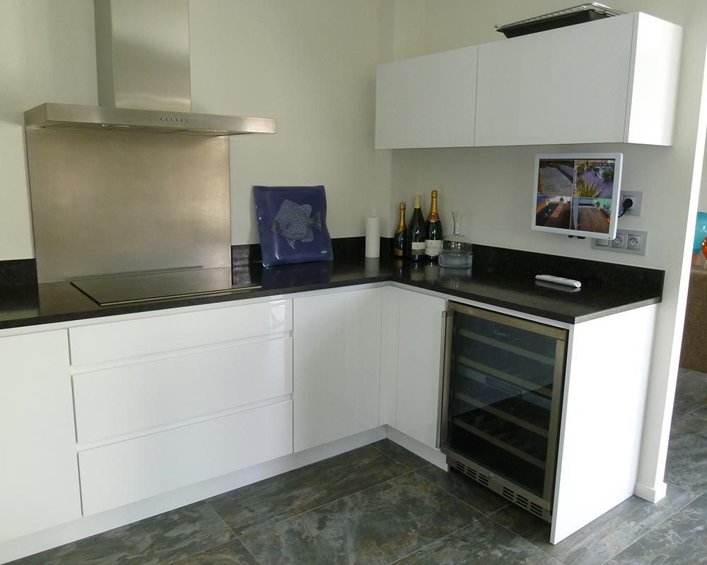 espace cuisine de couleur blanche et plan de travail noir