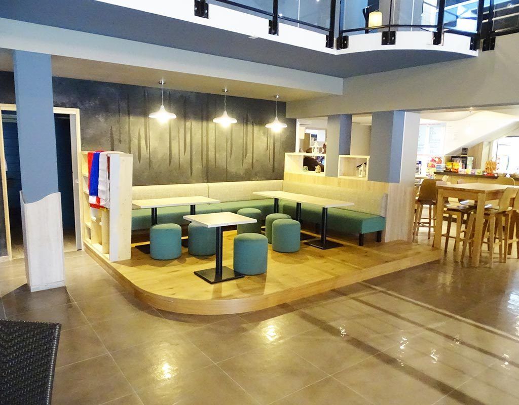 coin repas surélevé sur une plateforme avec du mobilier en tissu vert