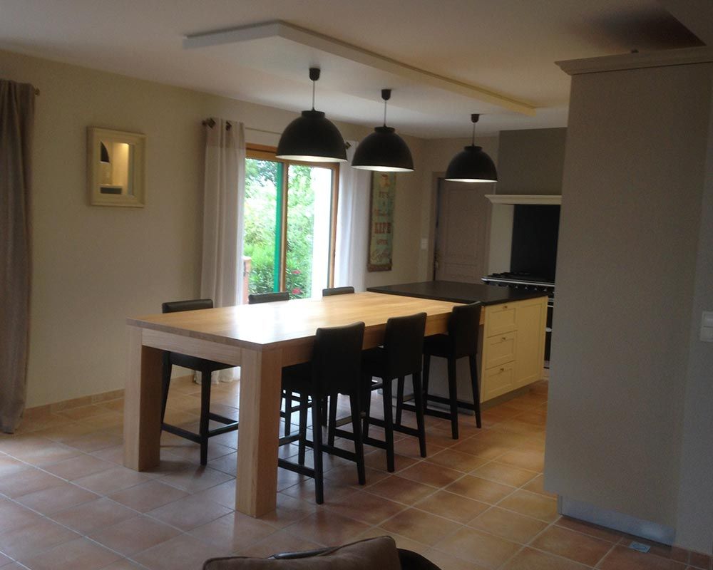 table en bois clair moderne et chaises de bar noires