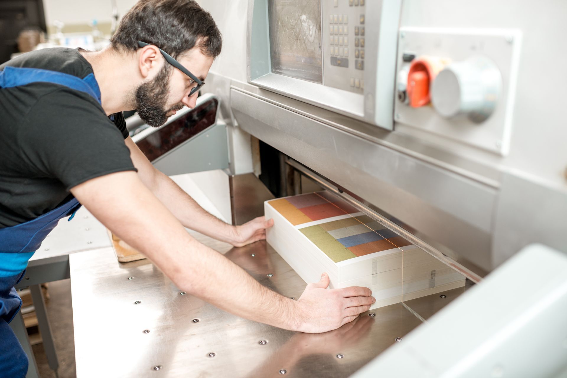 Personne réalisant une coupe de papier avec une machine industrielle.