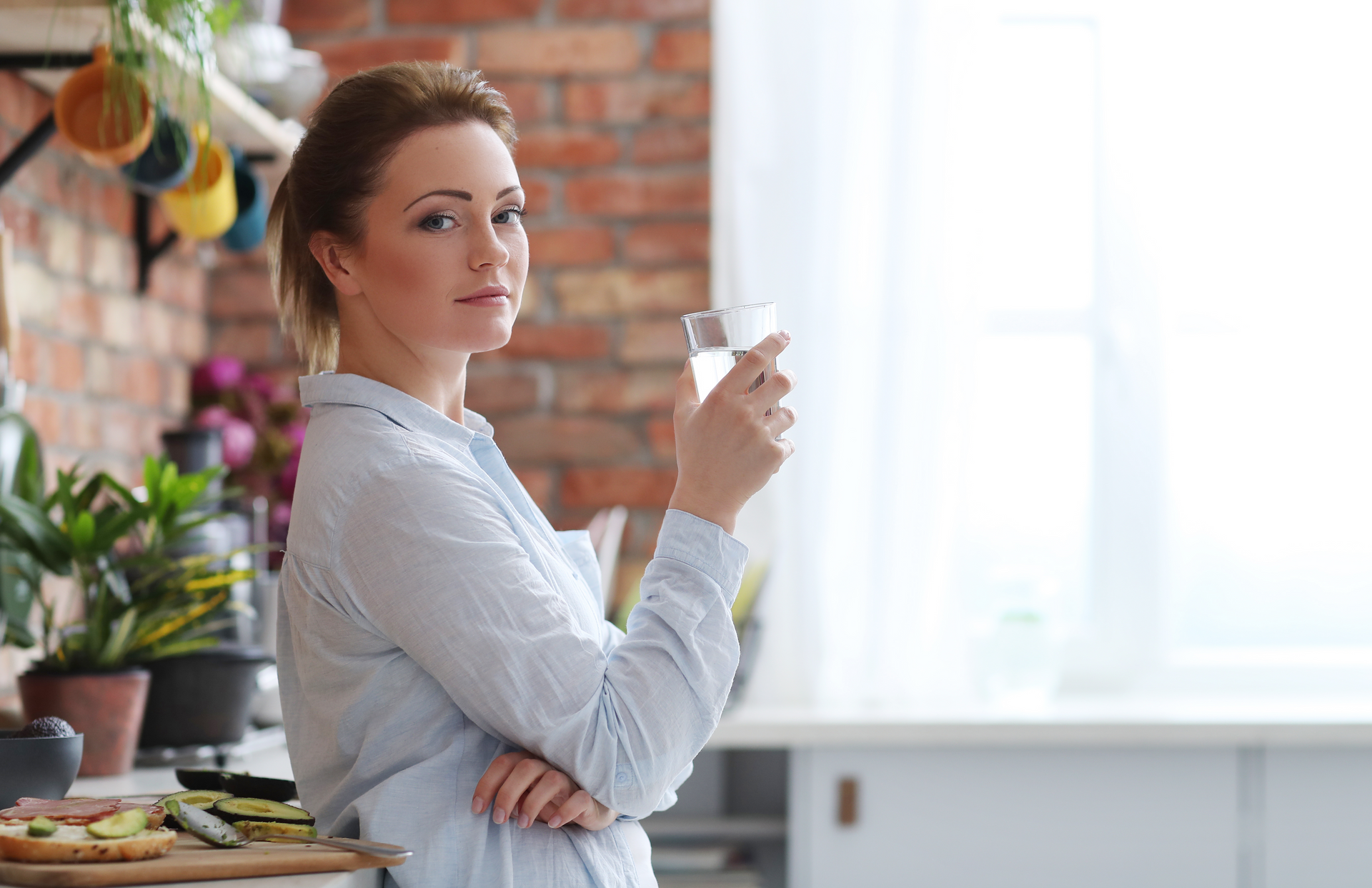Femme avec un verre d'eau dans une cuisine