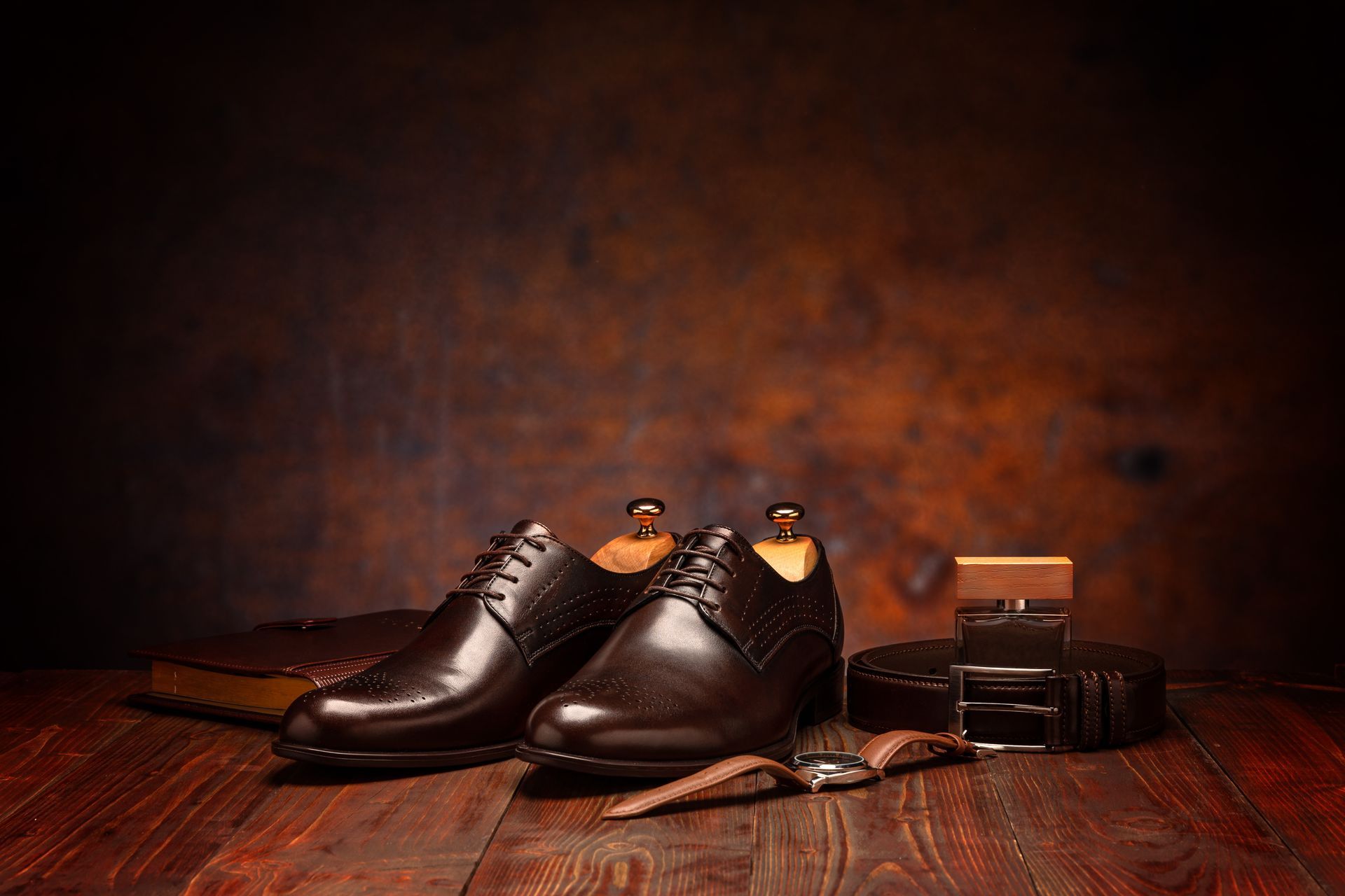 Une paire de chaussures avec une montre au bracelet en cuir et du cirage.