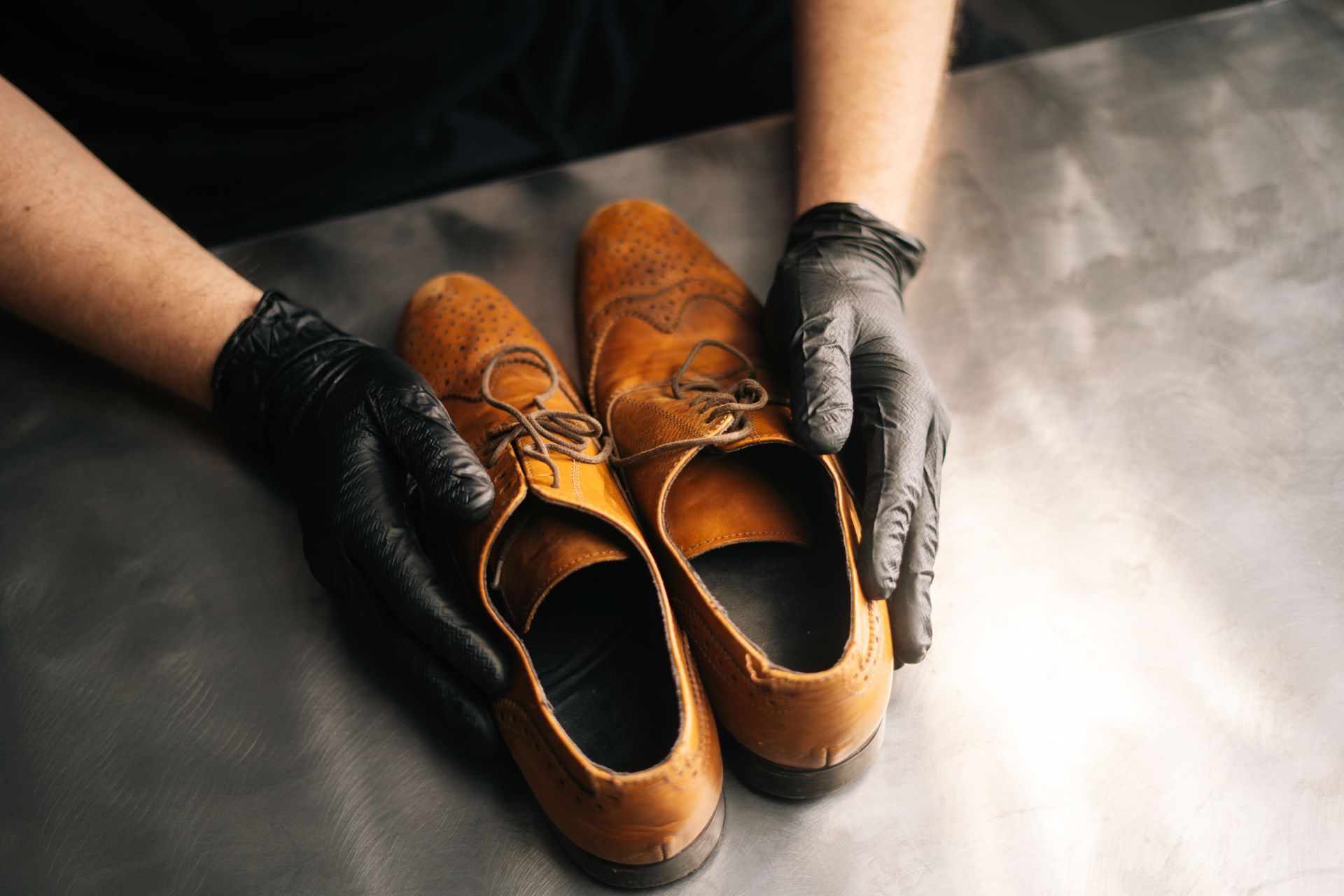 Une personne tenant une paire de chaussures usées.