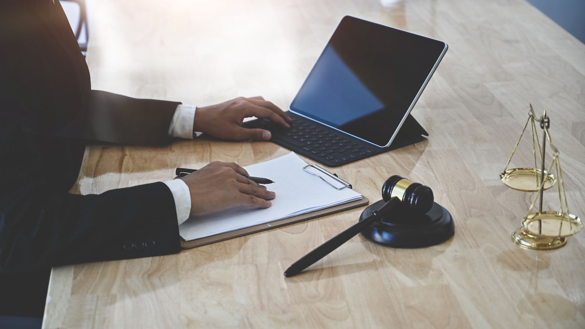 Un hombre está sentado en una mesa usando una computadora portátil.