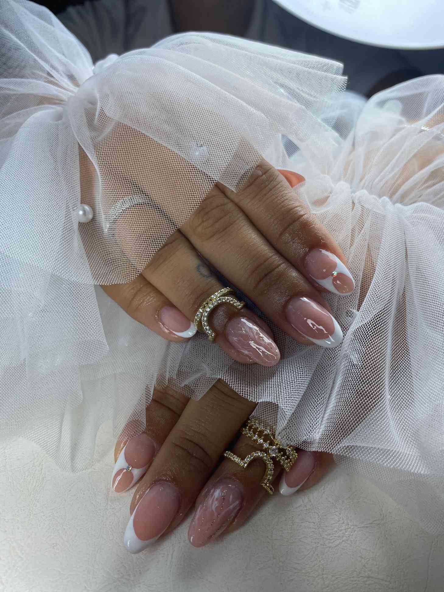 Un primer plano de las uñas de una mujer con anillos en ellas.