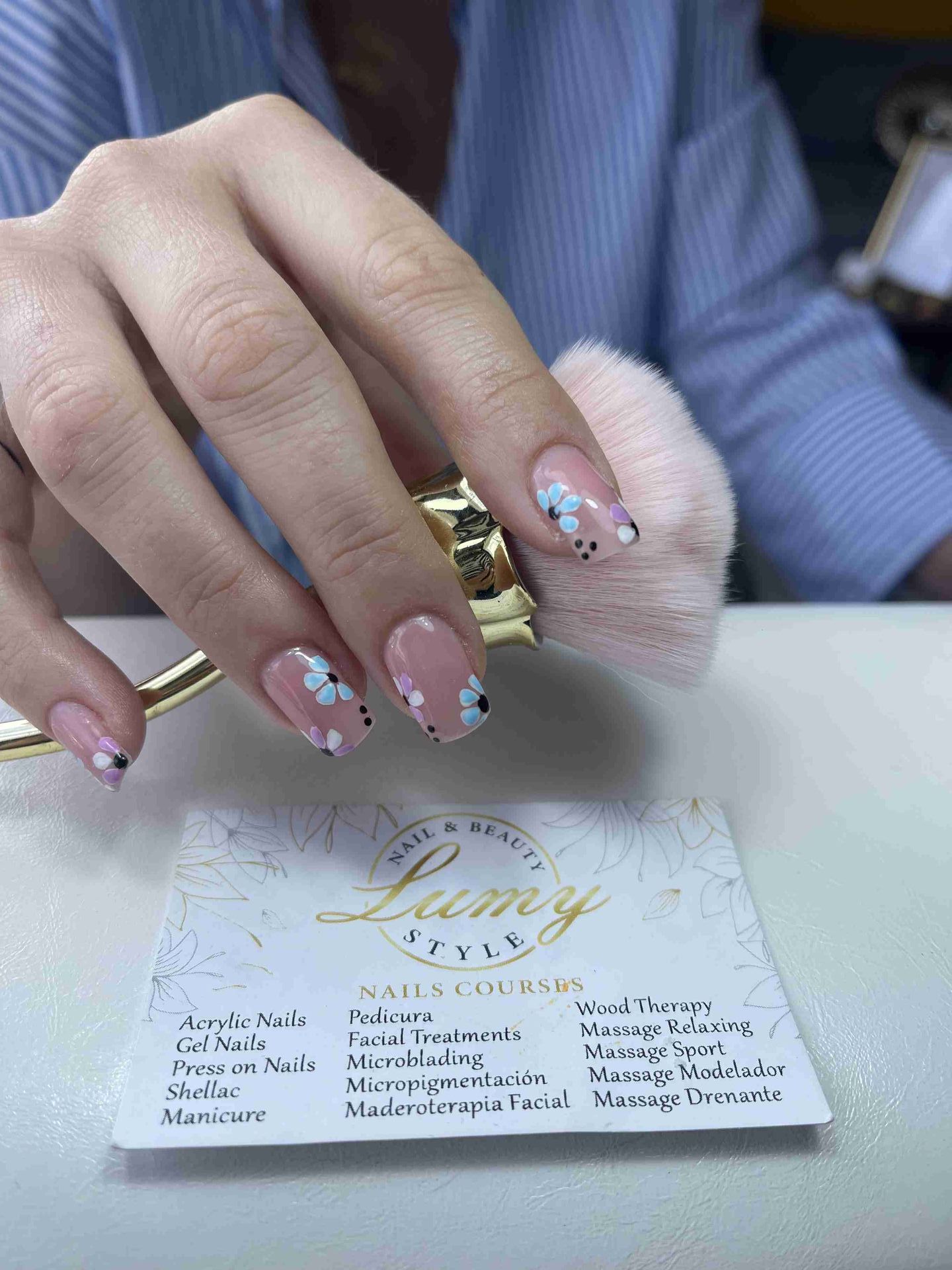Un primer plano de las uñas de una mujer y una tarjeta de presentación.