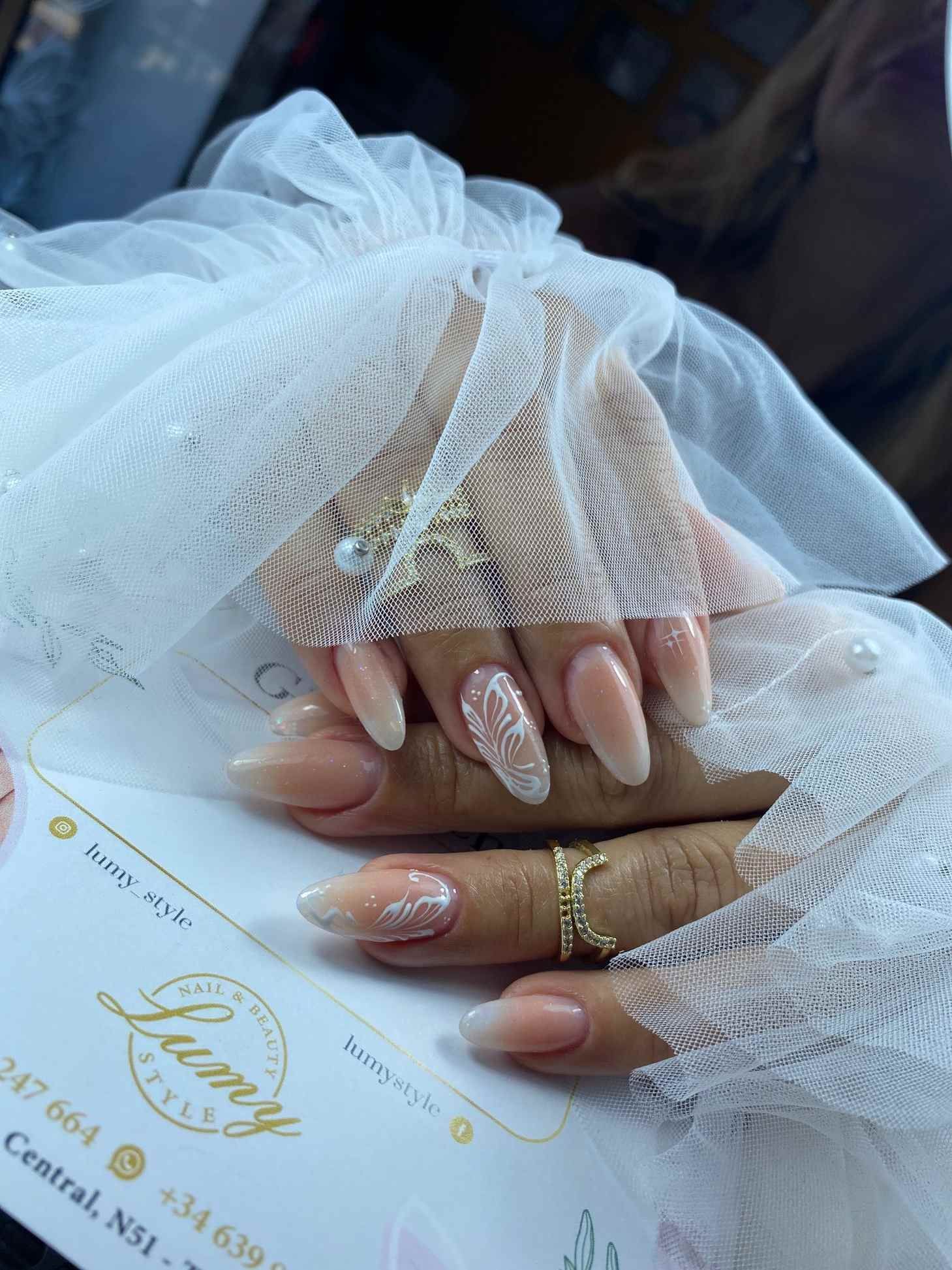 Un primer plano de las uñas de una mujer con un anillo en el dedo.