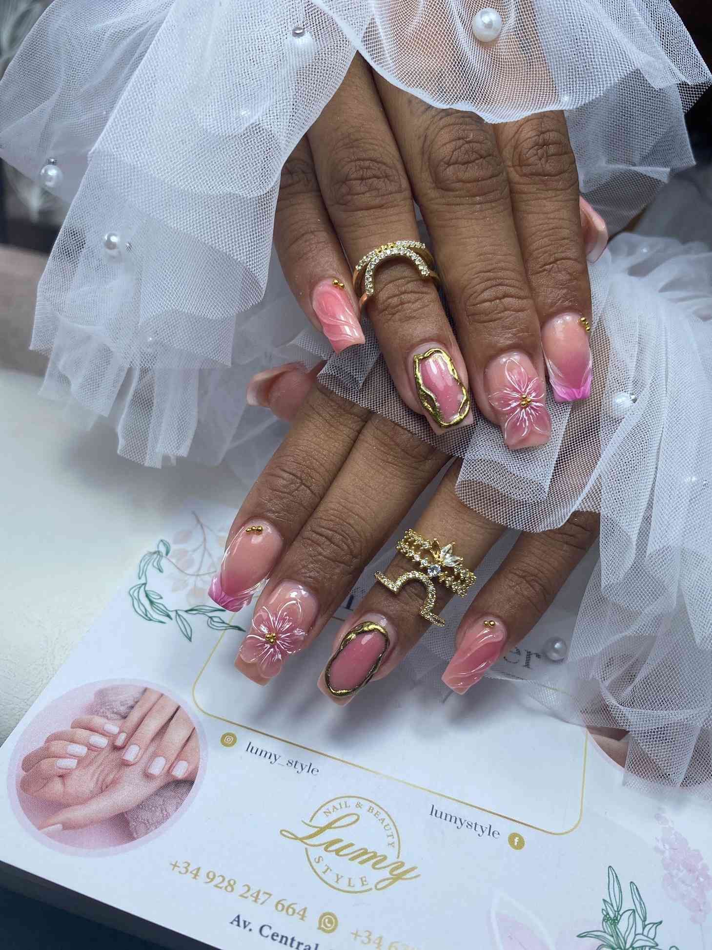 Un primer plano de las uñas de una mujer con anillos en ellas.