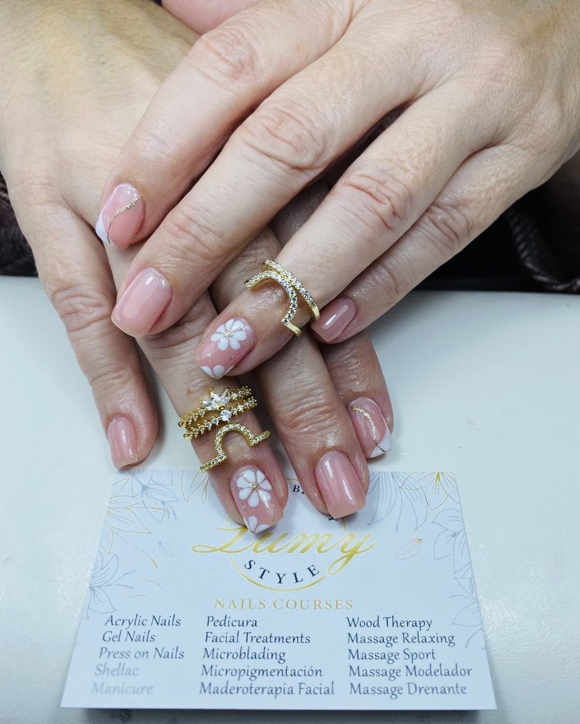 Un primer plano de las uñas de una mujer con anillos en ellas.