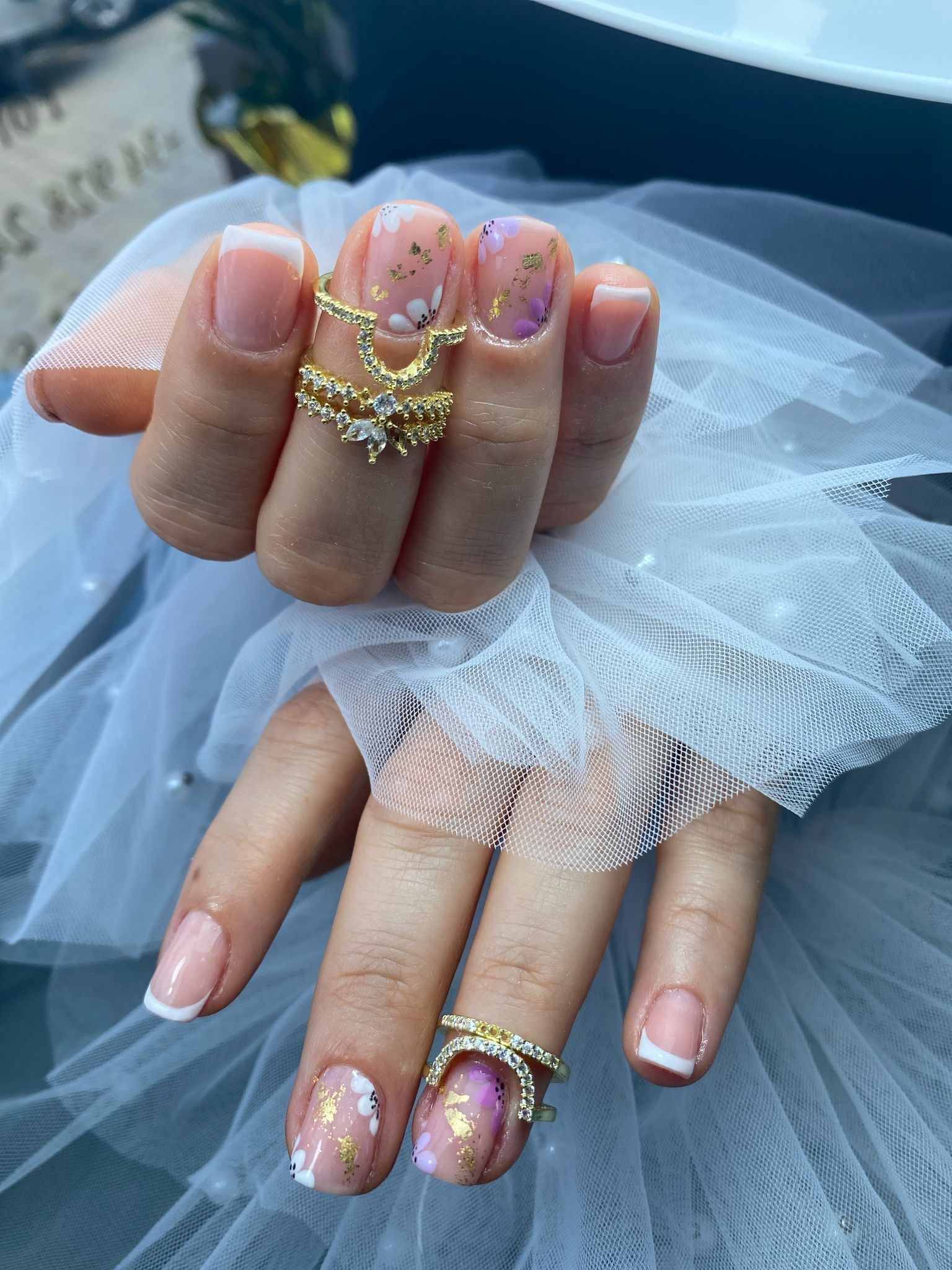 Un primer plano de las uñas de una mujer con anillos en ellas.