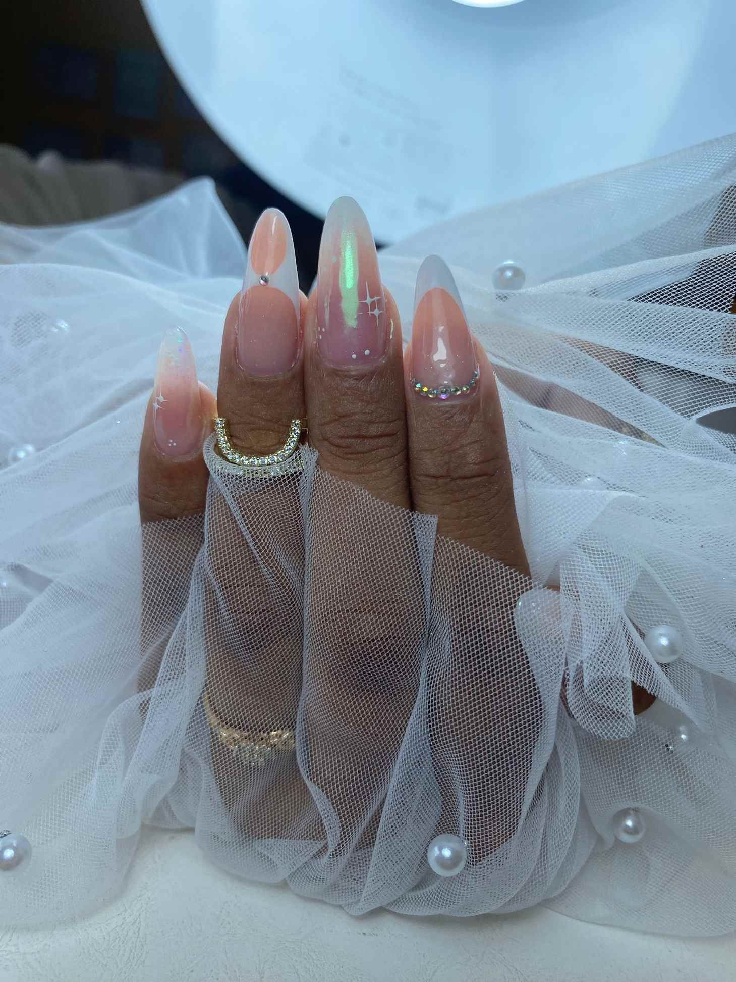 Un primer plano de las uñas de una mujer con anillos en ellas.