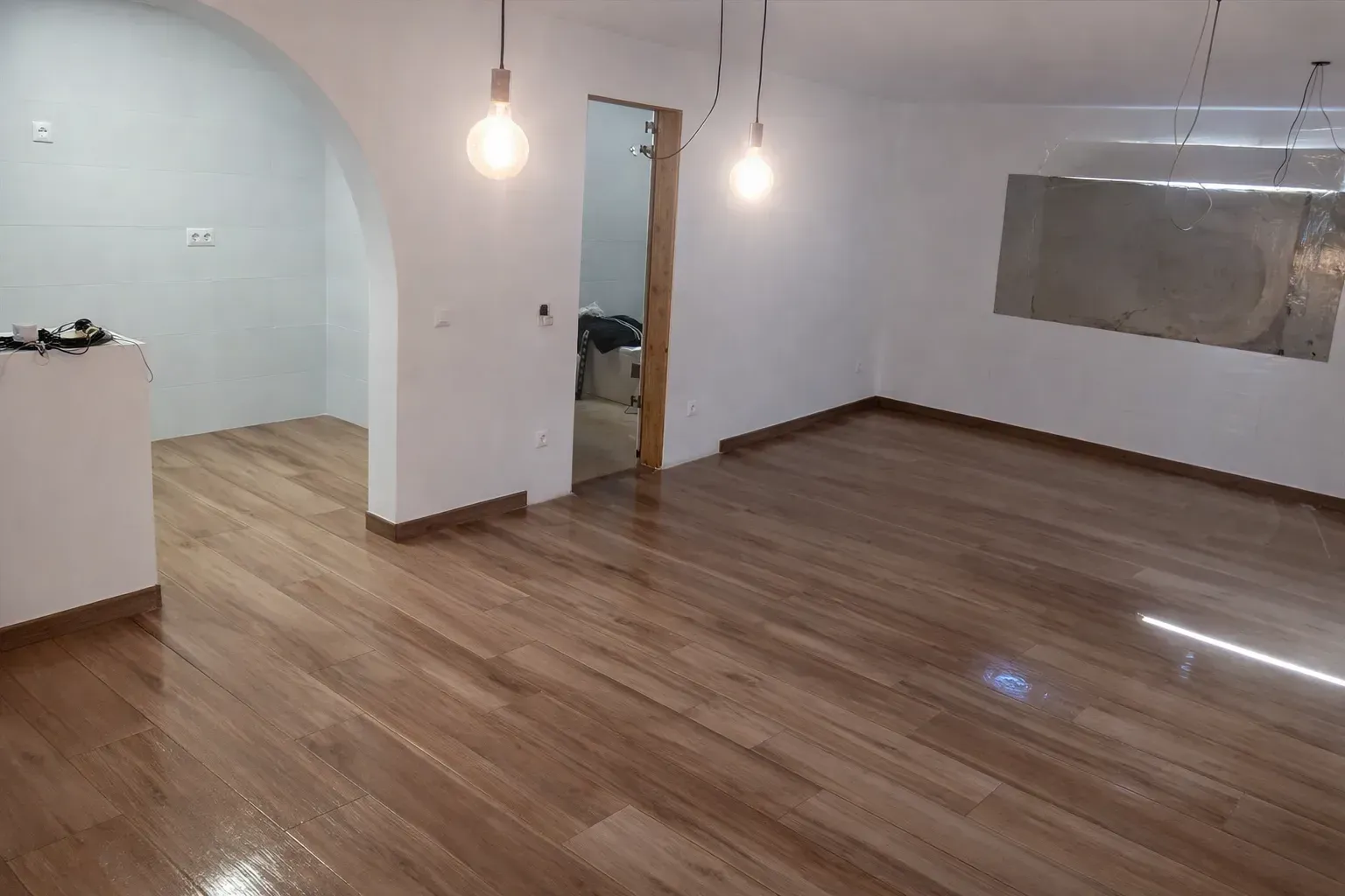 Fotografía del interior de una habitación vacía con suelo de imitación madera