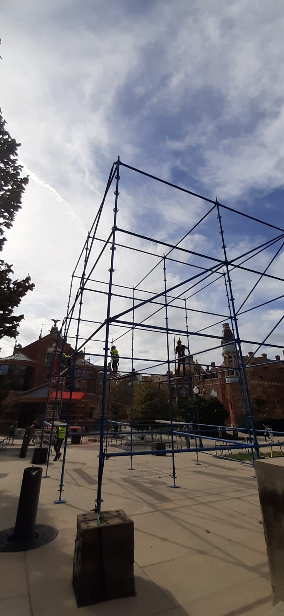 Estructura de cubo esquelético azul en un parque contra un cielo nublado.