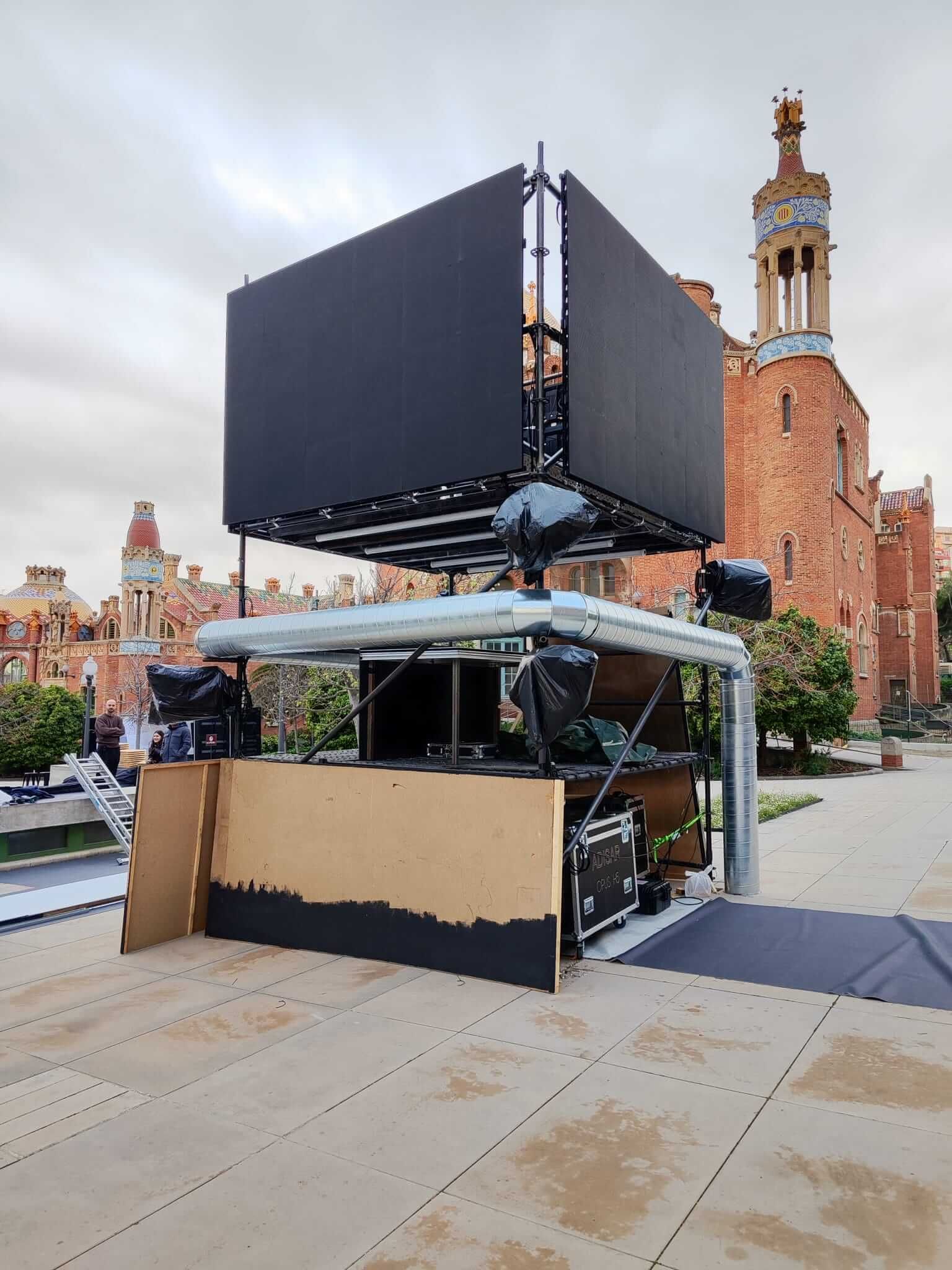 Escenario móvil con pantalla grande, instalado frente a un edificio histórico de ladrillo.