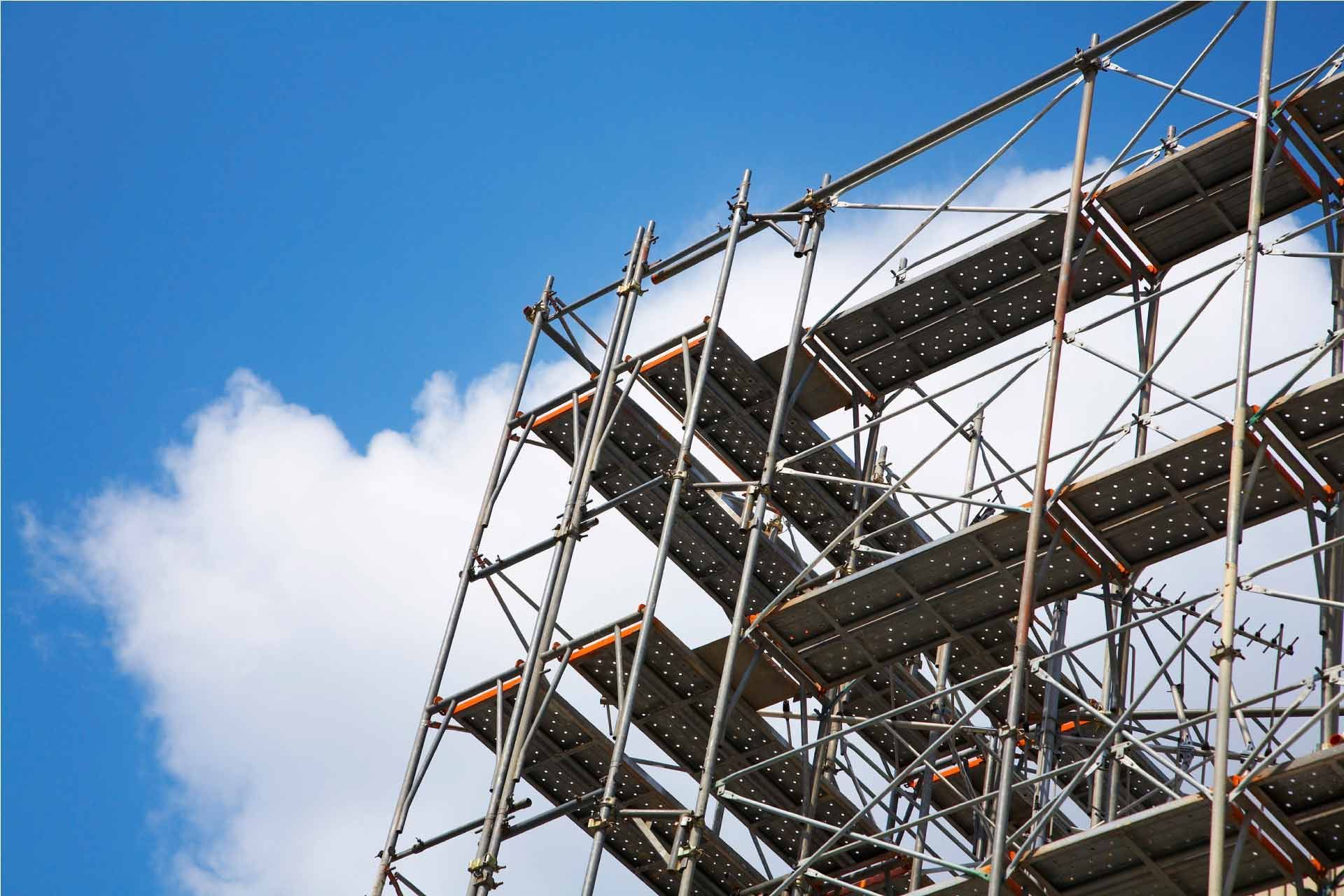 Andamios contra un cielo azul con nubes blancas esponjosas.