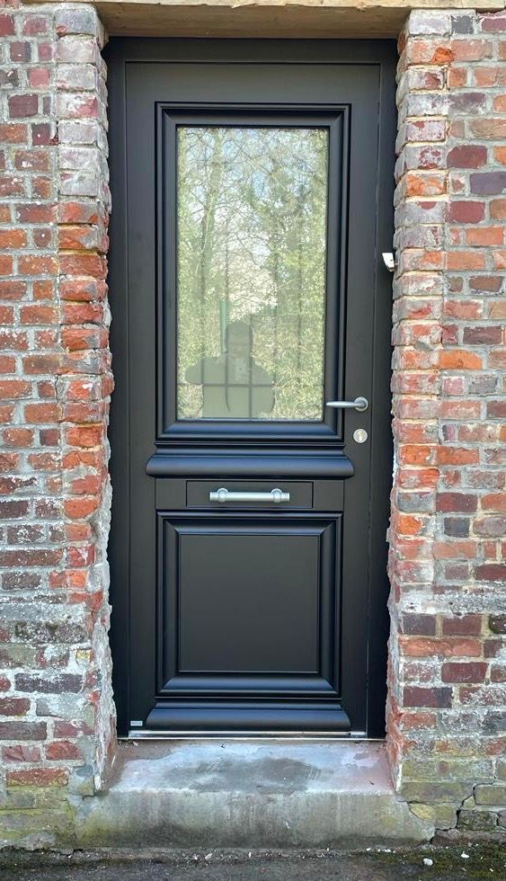 Porte d'entrée grise avec plusieurs ouvertures.