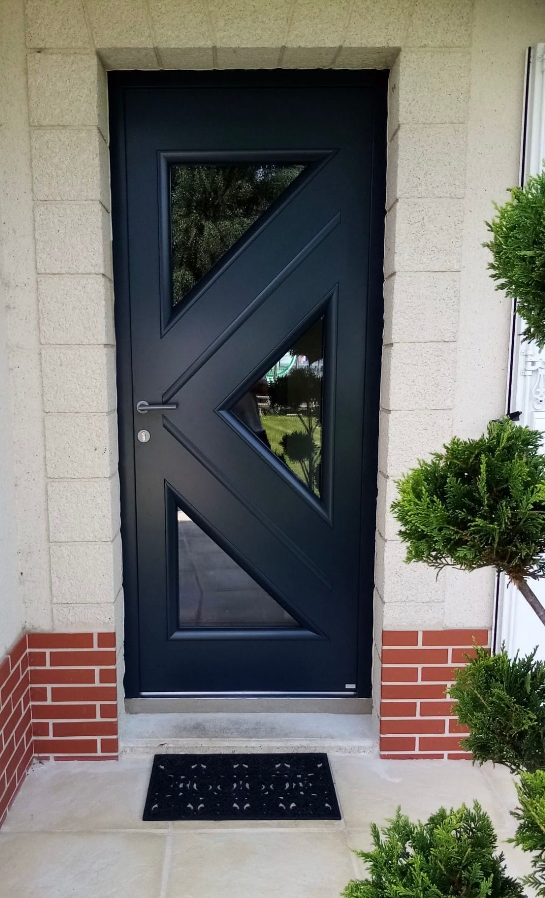 Porte d'entrée grise avec plusieurs ouvertures.