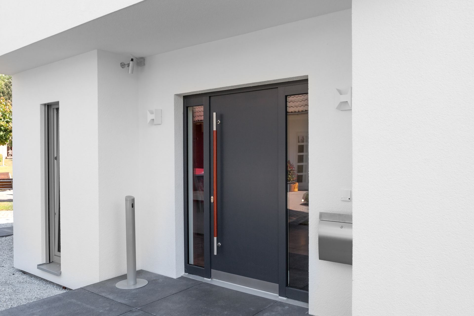 Porte d'entrée grise avec vitrage.