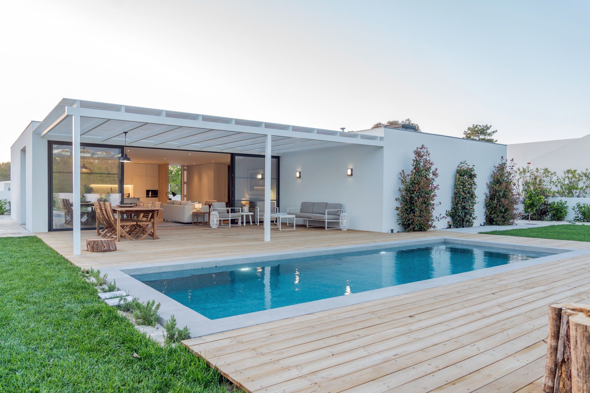 Maison avec une pergola et une piscine en premier plan.