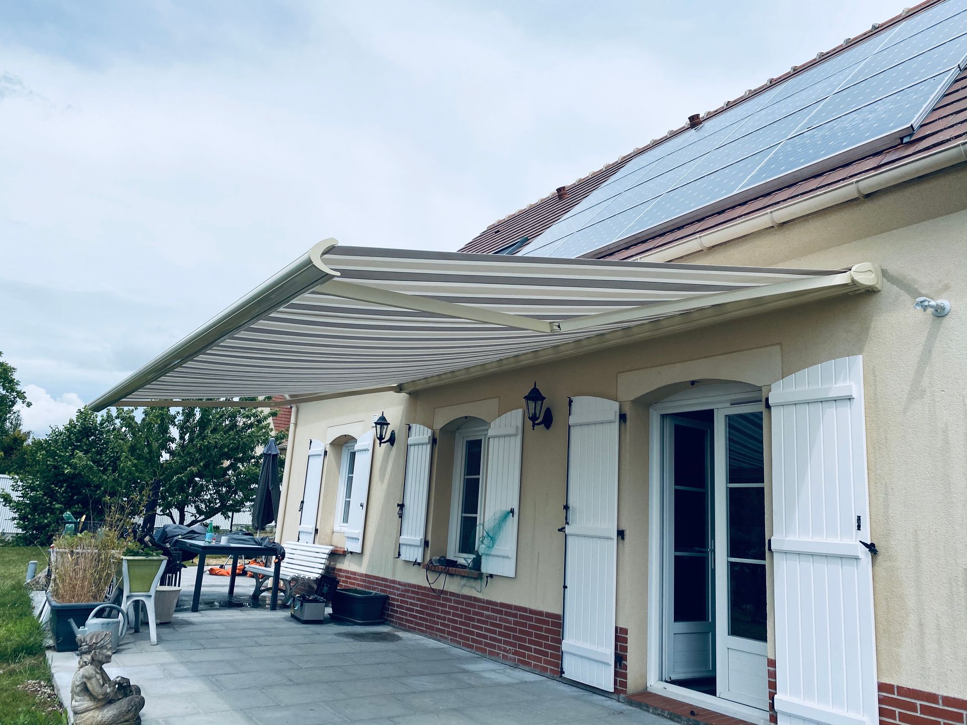 Store banne ouvert au-dessus d'une terrasse.