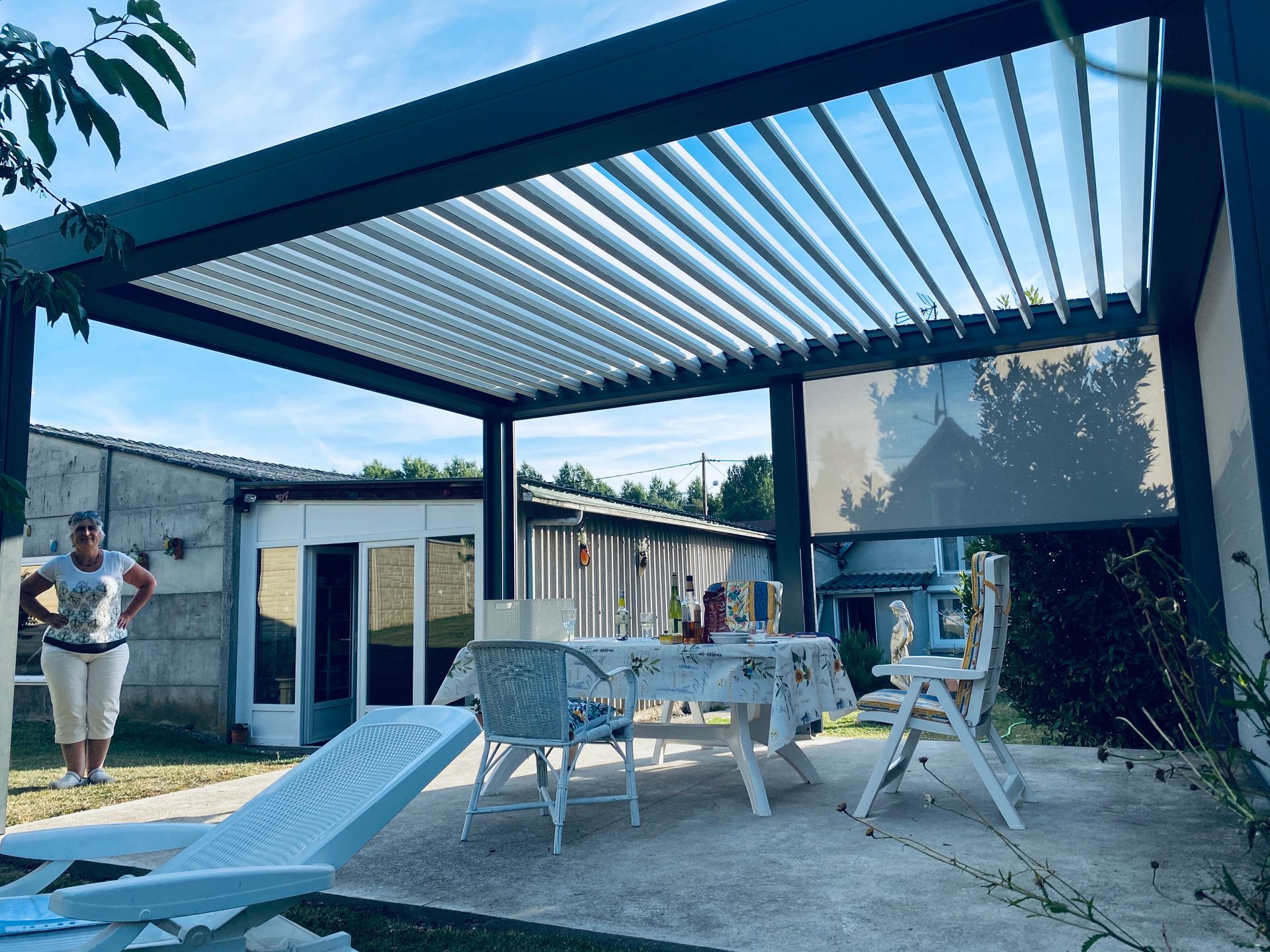 Pergola bioclimatique avec un salon de jardin.