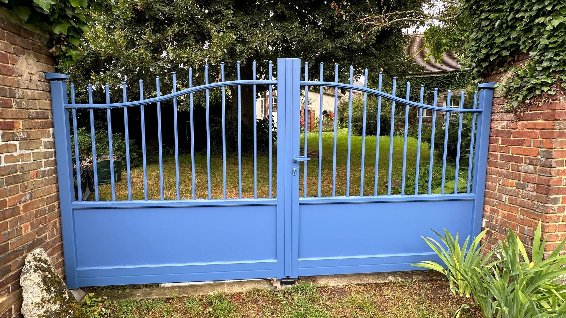 Portail battant bleu en fer.