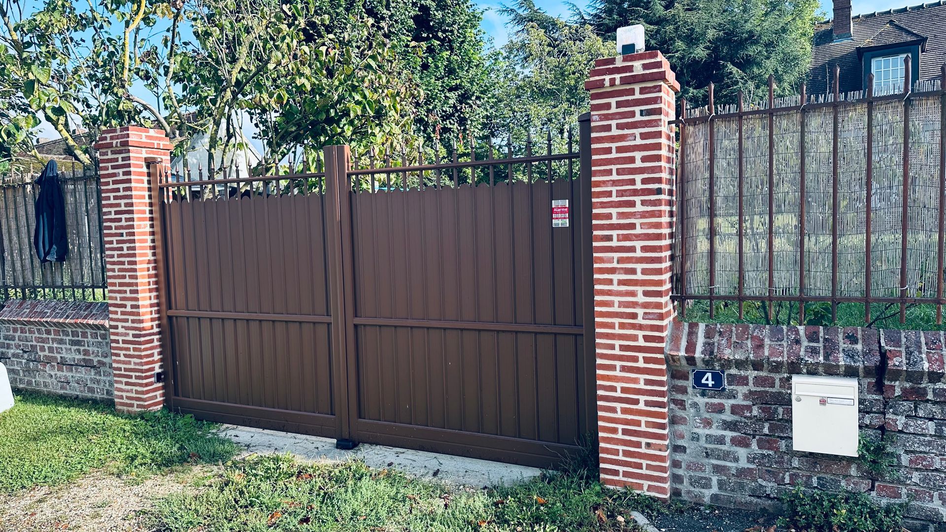 Portail battant marron en fer.