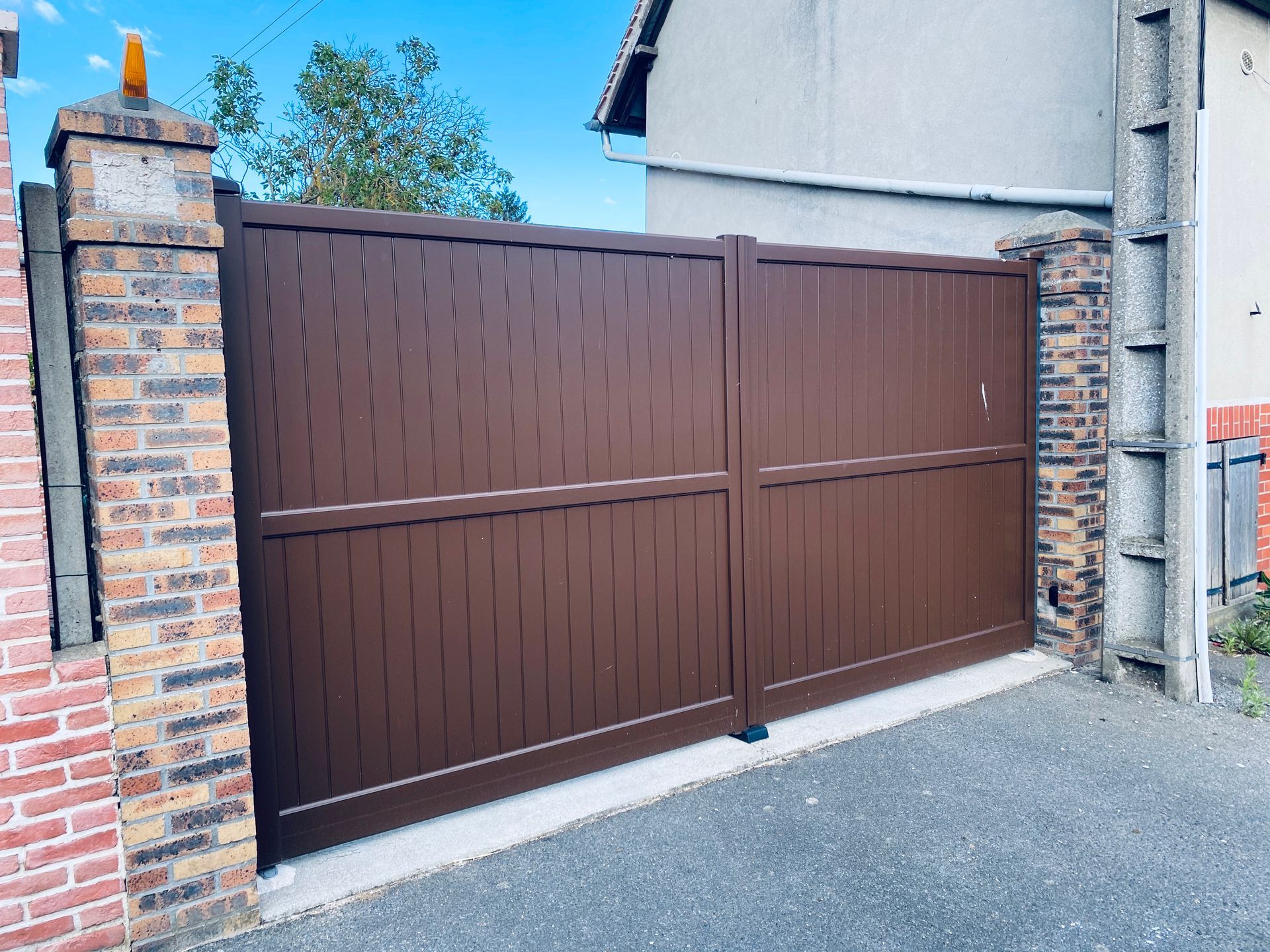 Portail battant marron.