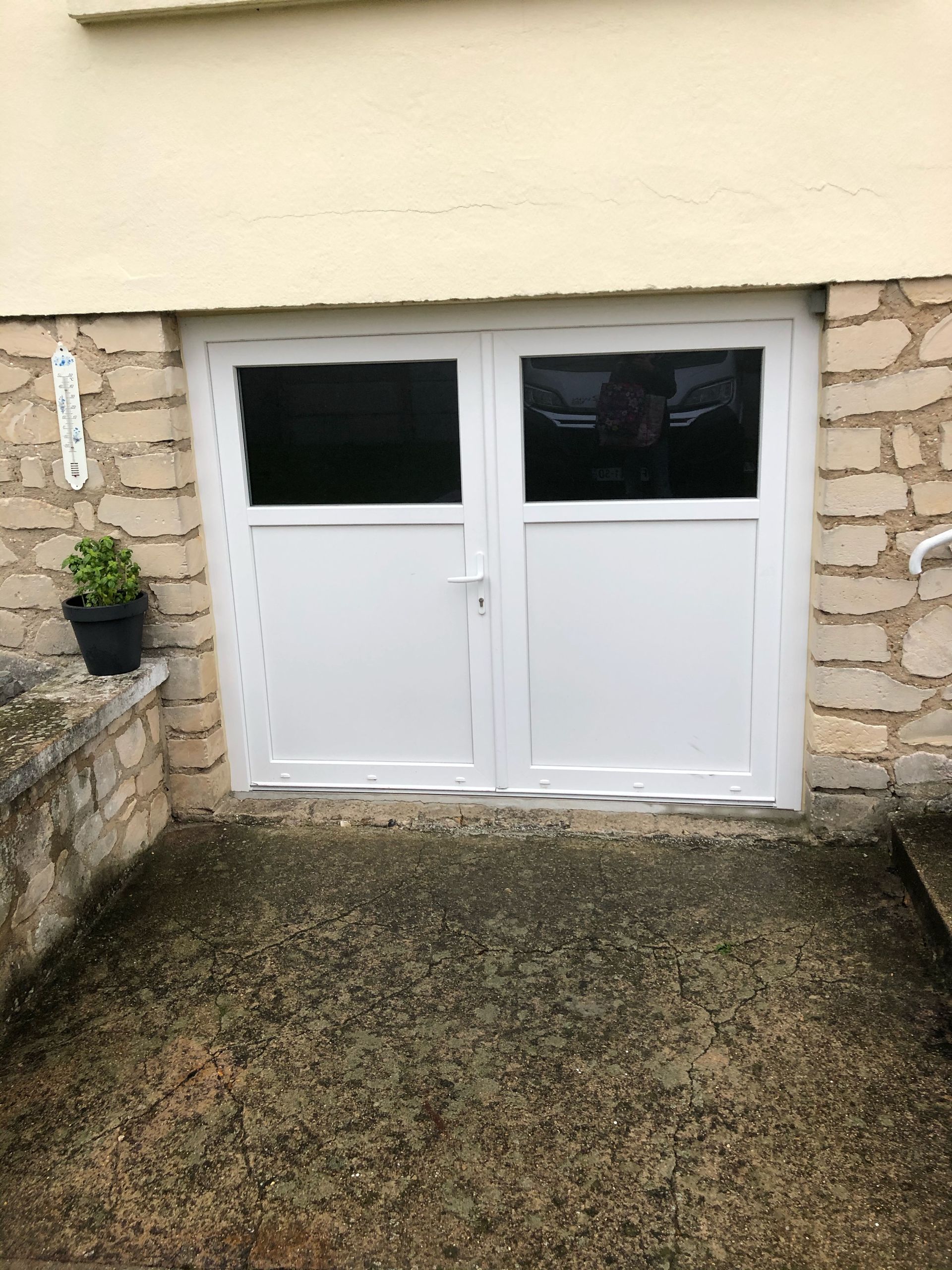 Porte de garage battante blanche.