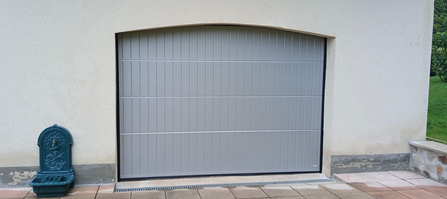 Porte de garage sectionnelle grise.