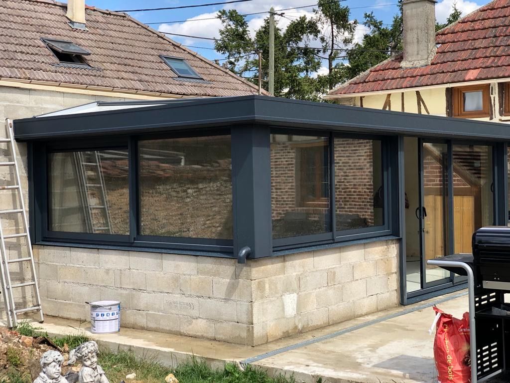 Véranda en aluminium avec le soubassement maçonné.