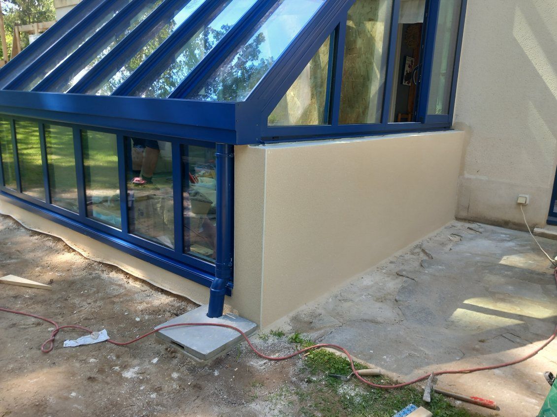 Véranda avec la structure en aluminium de couleur bleue.