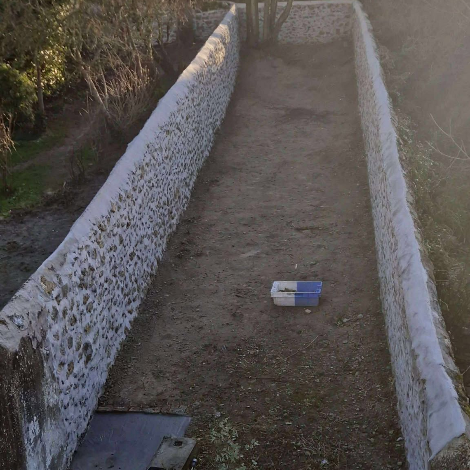 Terrain bordé de murs en pierre reconstruit.