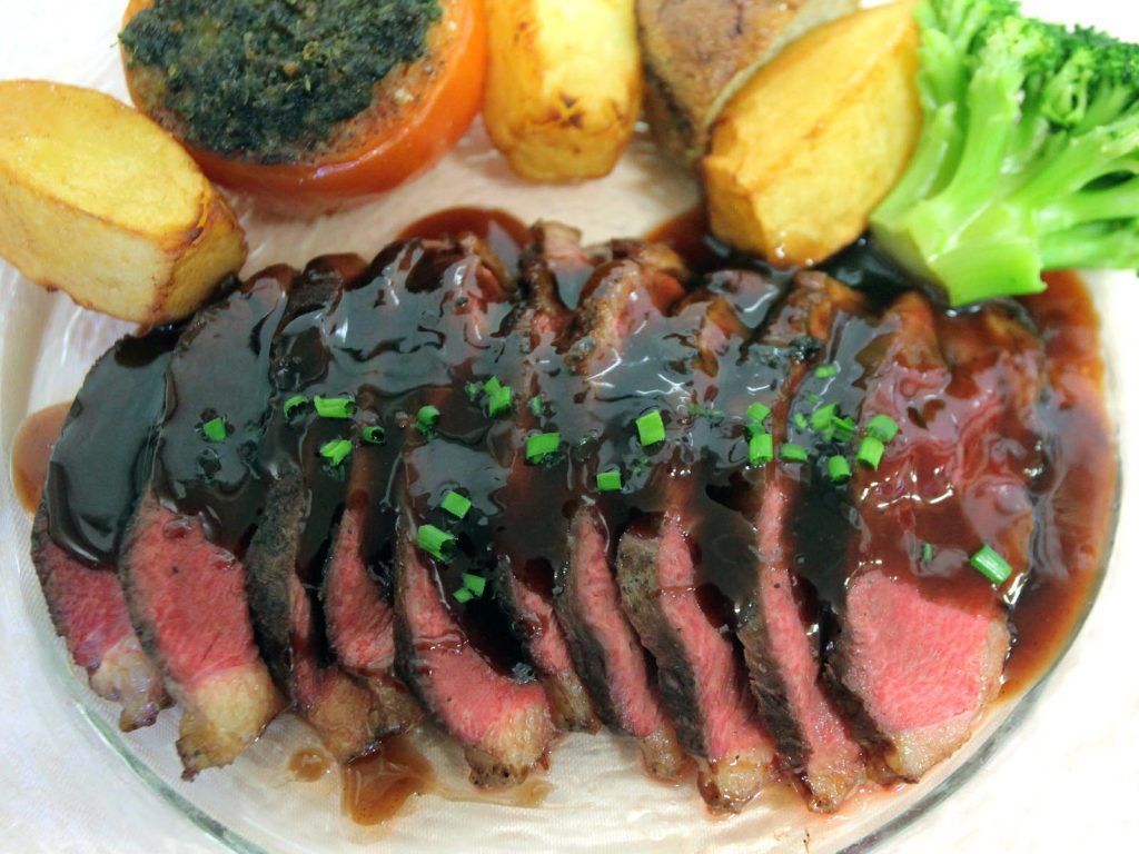 Un plat avec plusieurs tranches de viandes rouge.