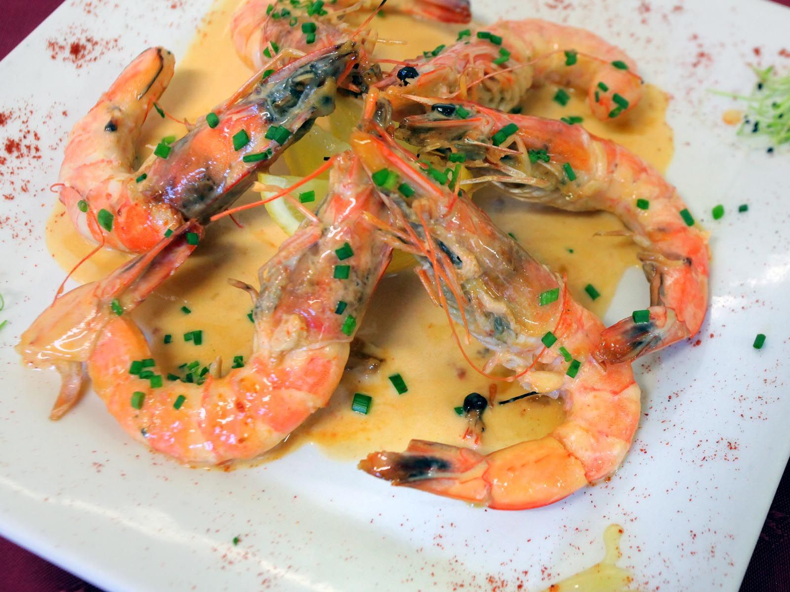 Des crevettes disposées en spirale dans une assiete.