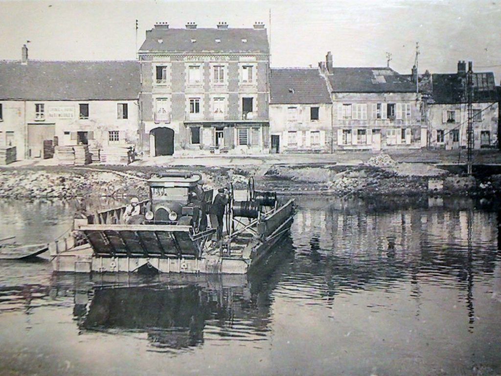 photographie en noir et blanc d'une barque traversant le fleuve.