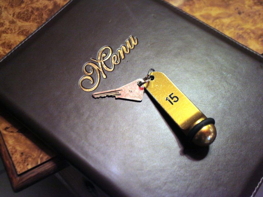 Clef de la chambre numéro 15 posé sur le livre des menus.