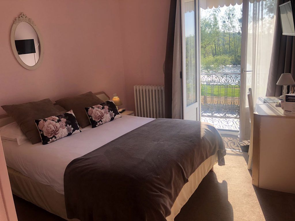 Lit double dans une chambre à proximité d'une porte fenêtre 01.